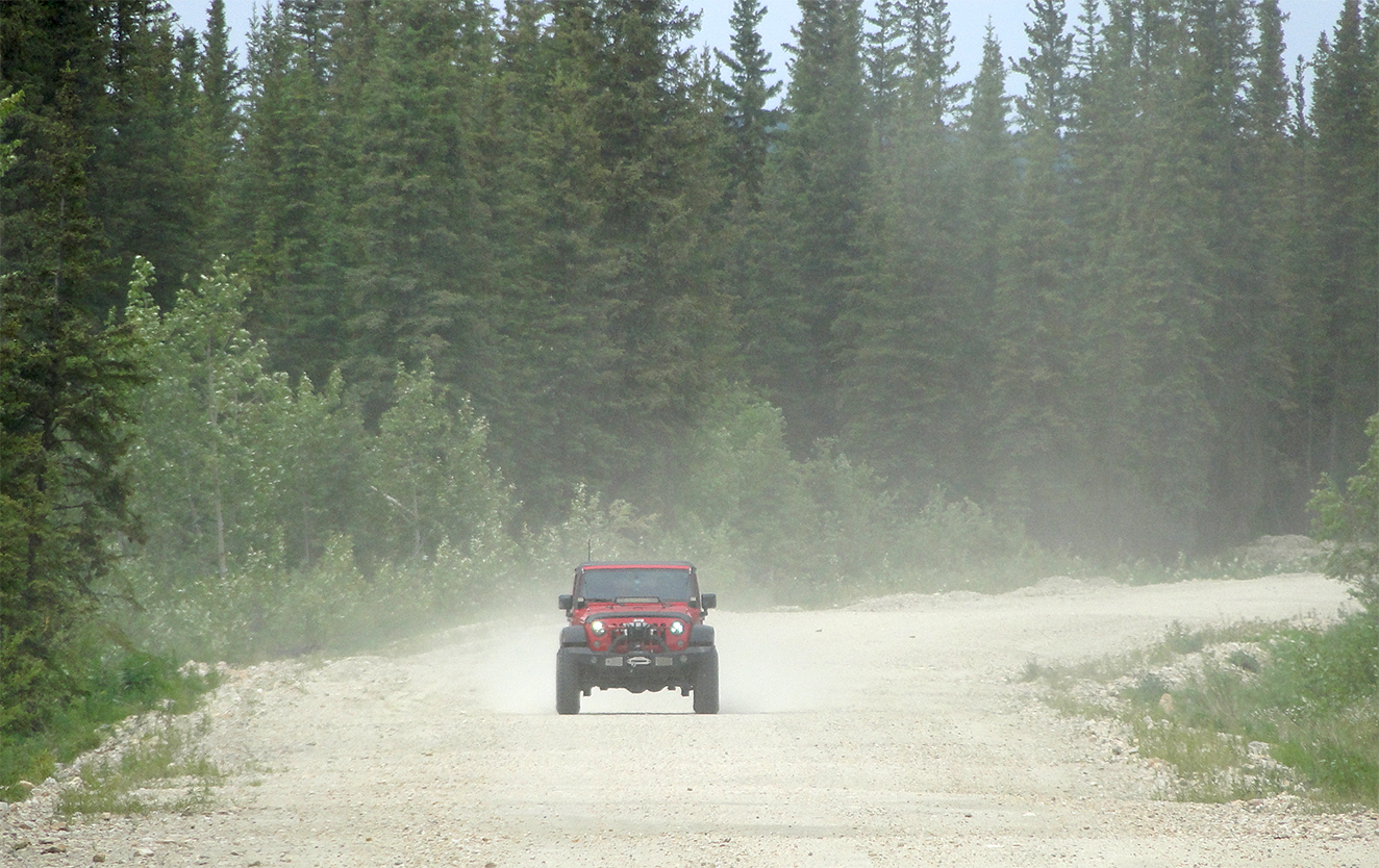 Dust on logging road driving my Jeep Wrangler JK